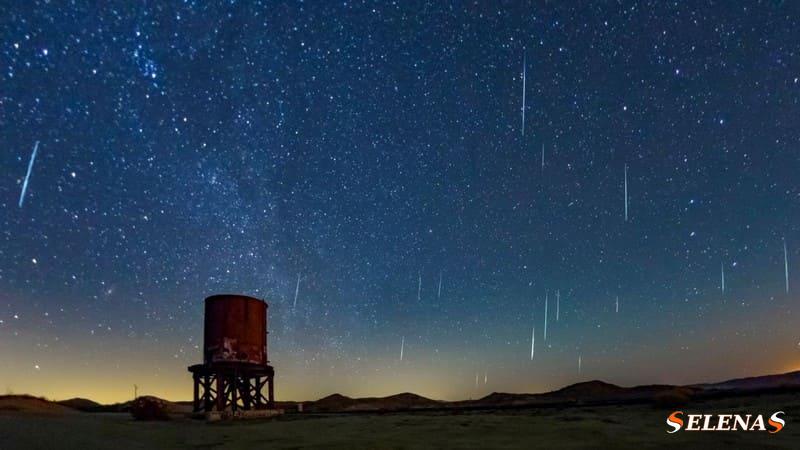 Метеоры проносятся по звездному небу над большой цистерной в пустыне.