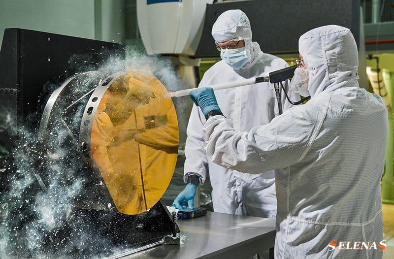 Инженеры очищают зеркало испытательного телескопа космического телескопа Джеймса Уэбба, обдувая его снегом из углекислого газа.
